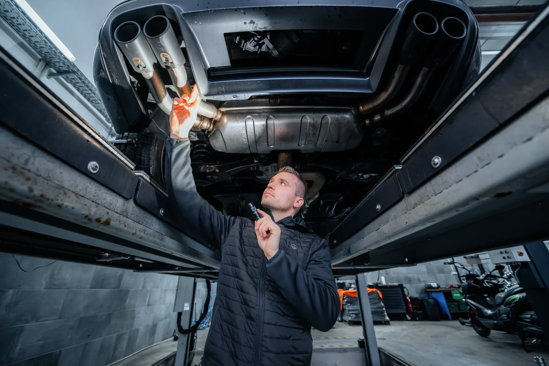 Professioneller KFZ-Mechaniker bei der Inspektion und Schadensbewertung eines Fahrzeugs